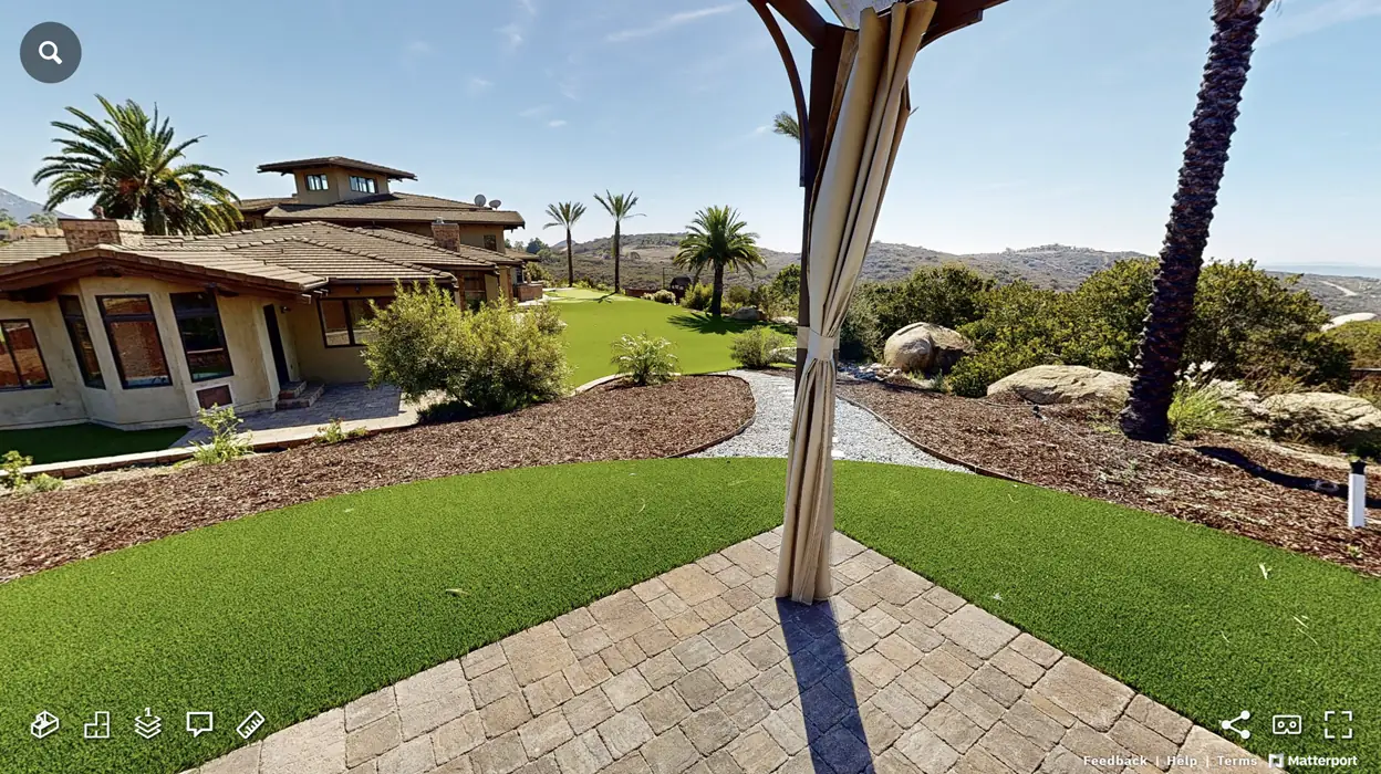 Matterport outdoor scan of a backyard with lawn, pavers and hillside views